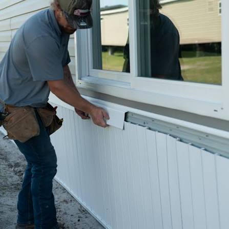 Crew installing skirting on a manufactured home