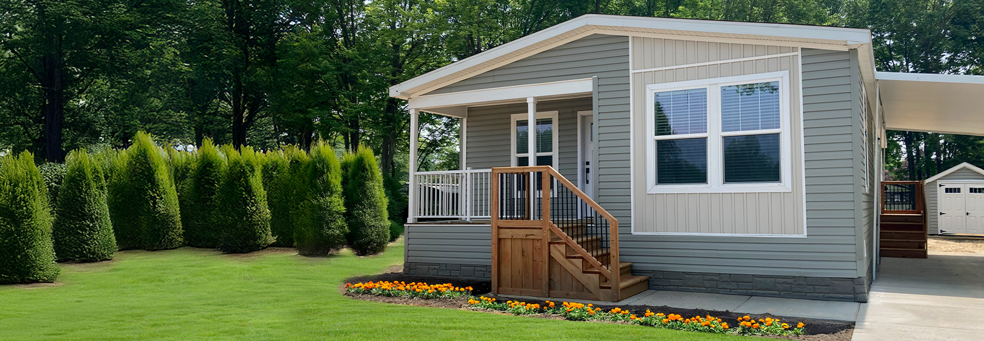 Manufactured home with a covered porch and flower beds